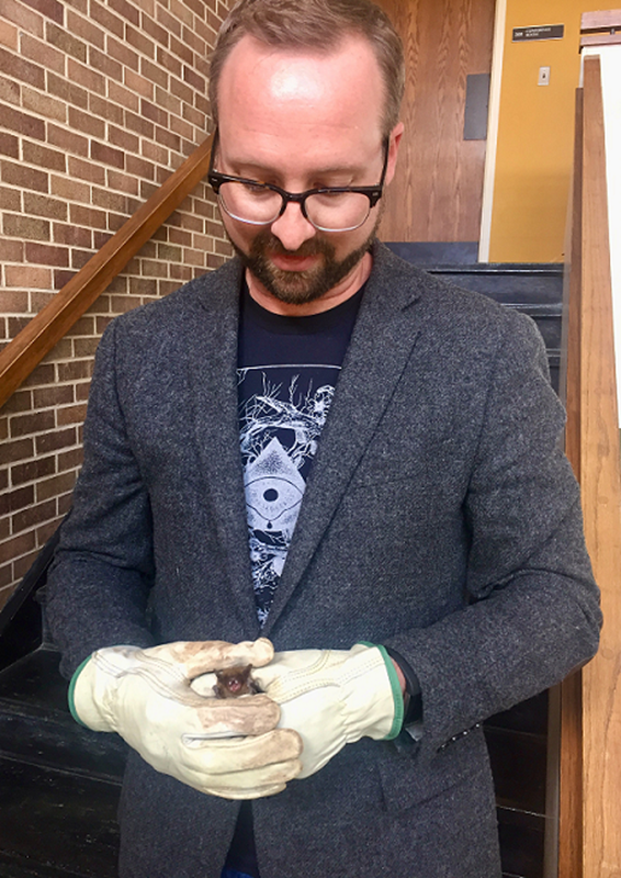 Mark Davis holding a bat in a stairwell