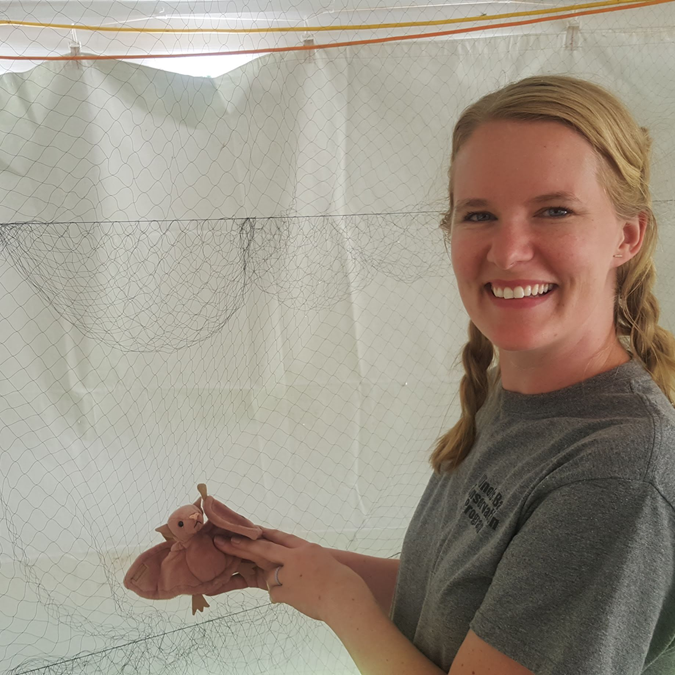 Tara in front of mist net with stuffed bat